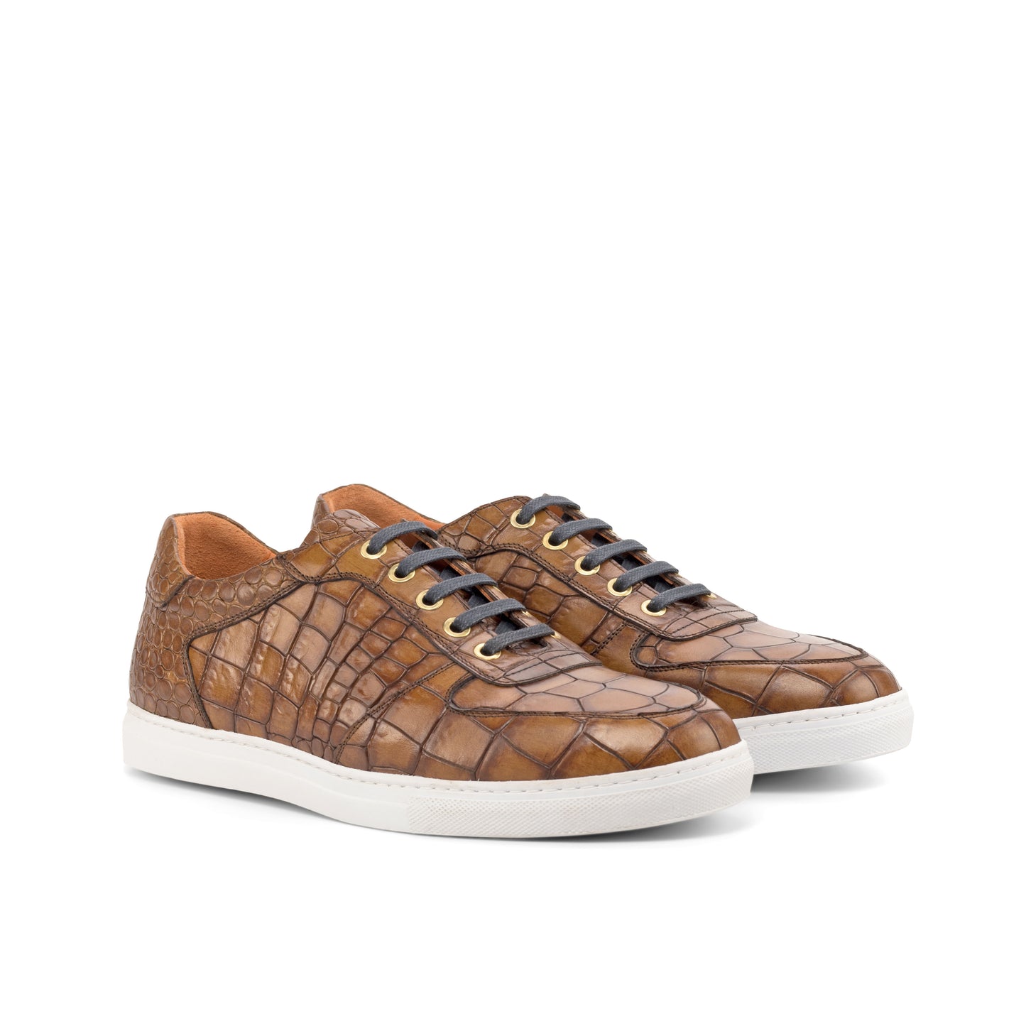 Brown crocodile-patterned sneakers with white soles on a white background