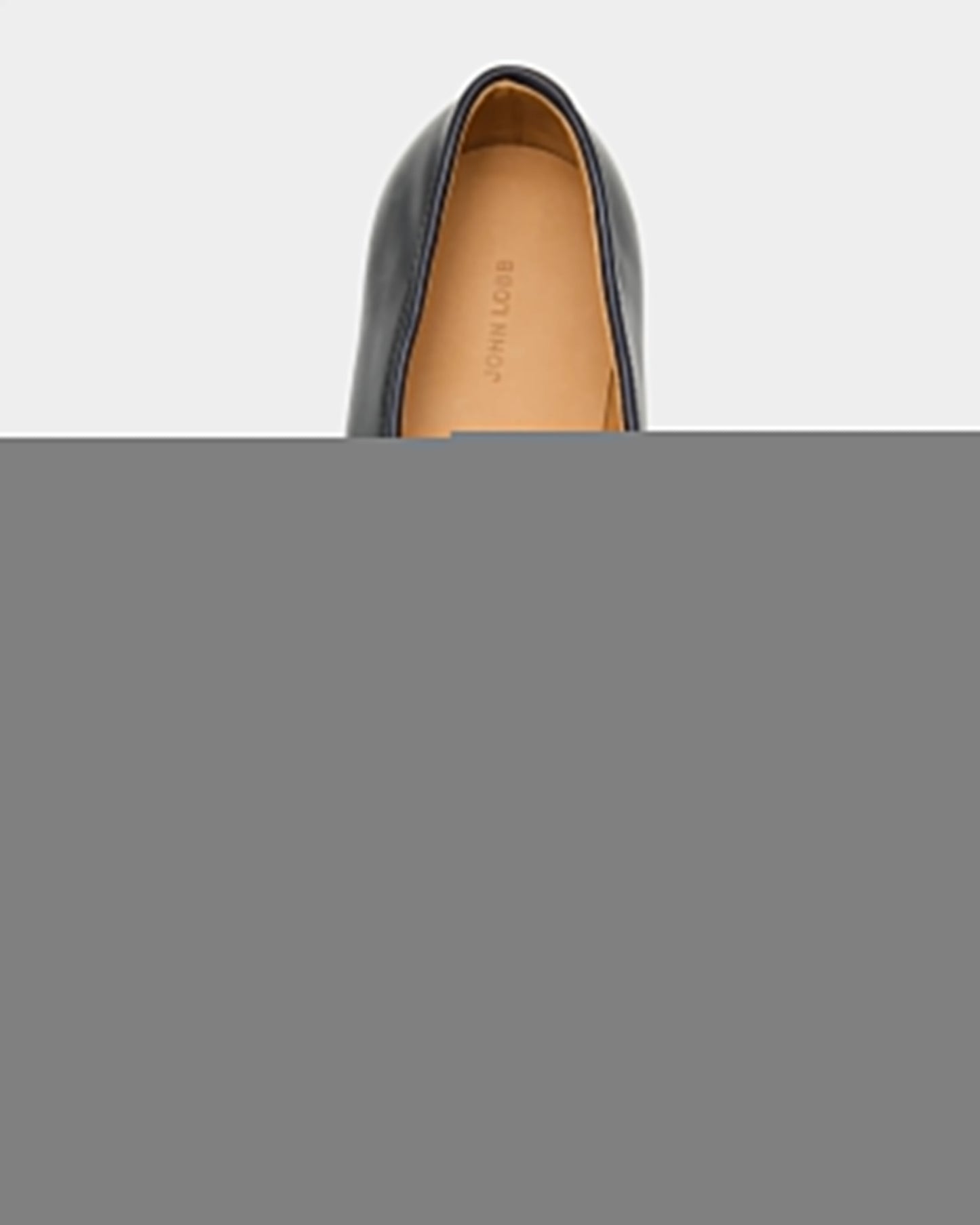 Black loafer shoe with navy textured sole on a white background