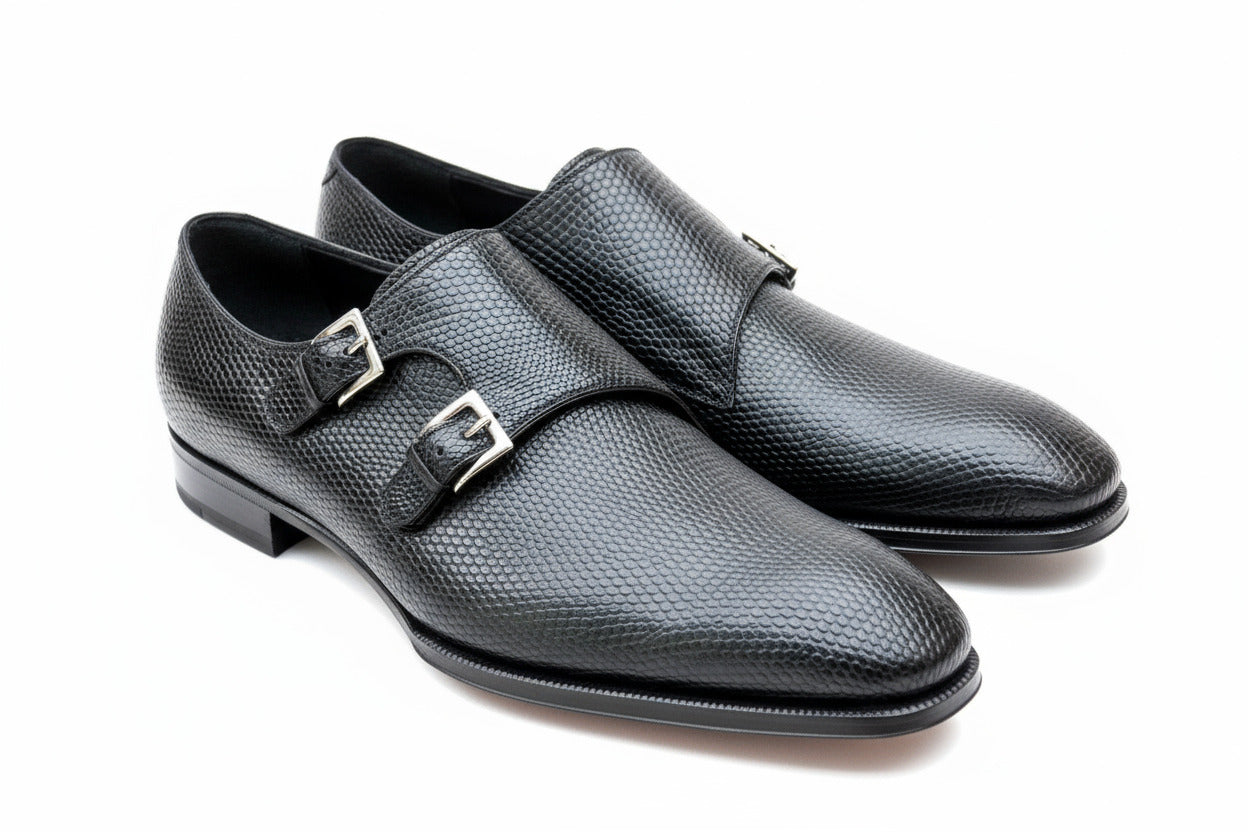 Pair of black leather shoes with buckles on a white background