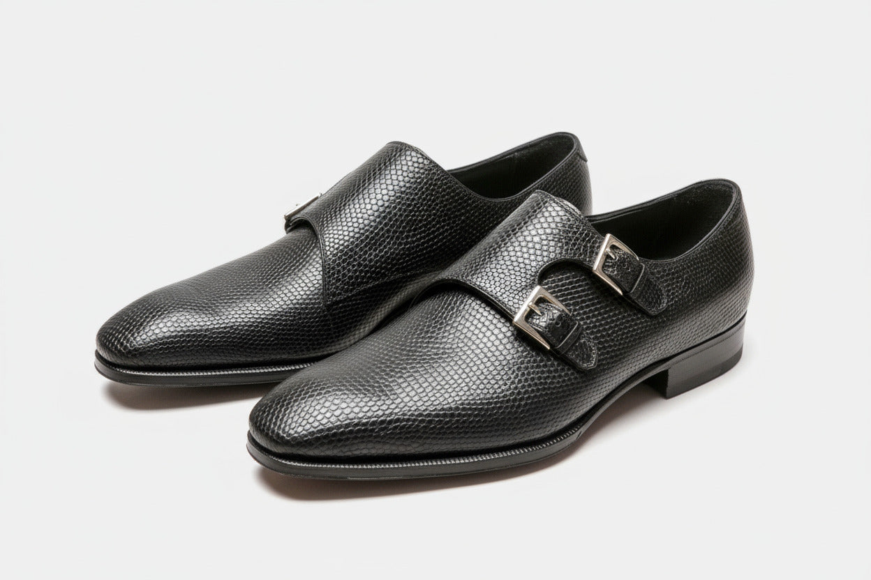 Pair of black leather shoes with buckles on a white background