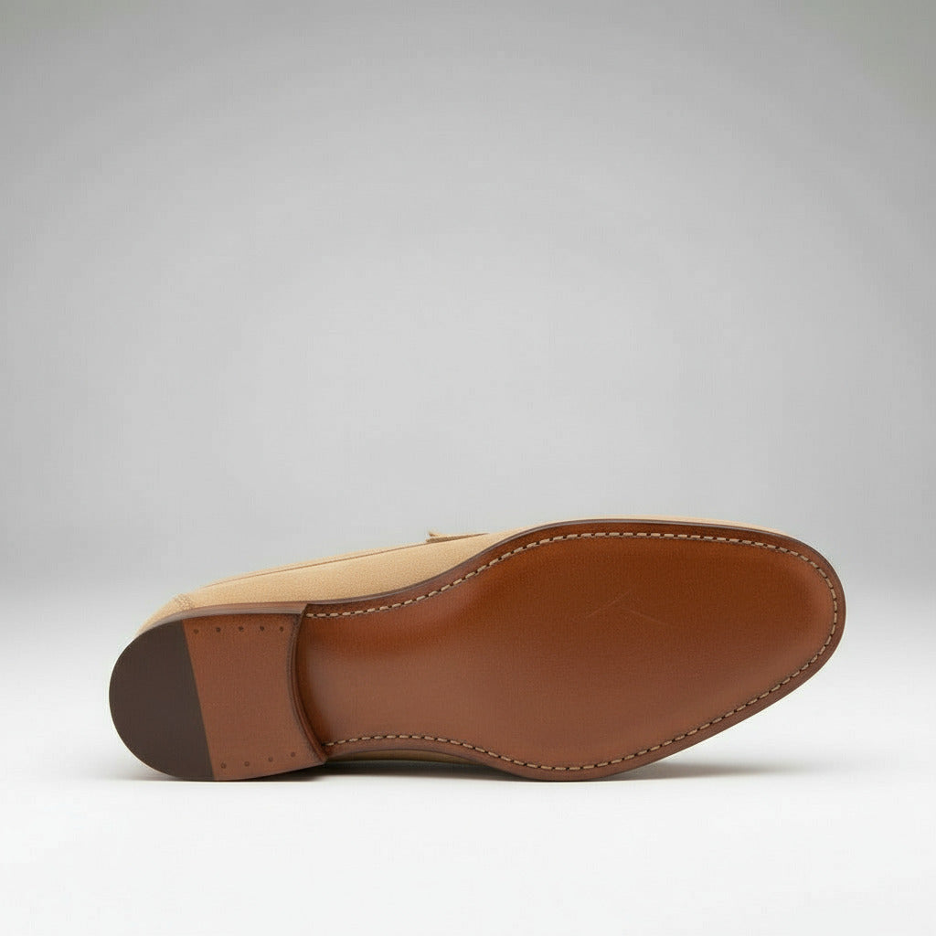 Pair of tan loafers on a light gray background