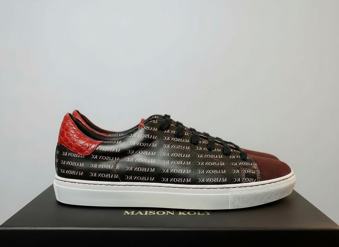 Brown sneaker with red accents and 'MAISON KOLY' branding on a blurred background