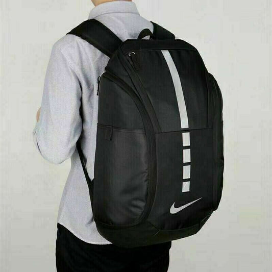 Black Nike backpack worn by a person on a plain background