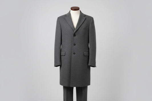 Gray coat on a mannequin against a plain background